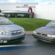 A 2009 AP photo that shows a 1990 Subaru Legacy L, the first car produced at SIA, and a 2010 Subaru Outback 2.5i, the three millionth vehicle to roll off the assembly line there.